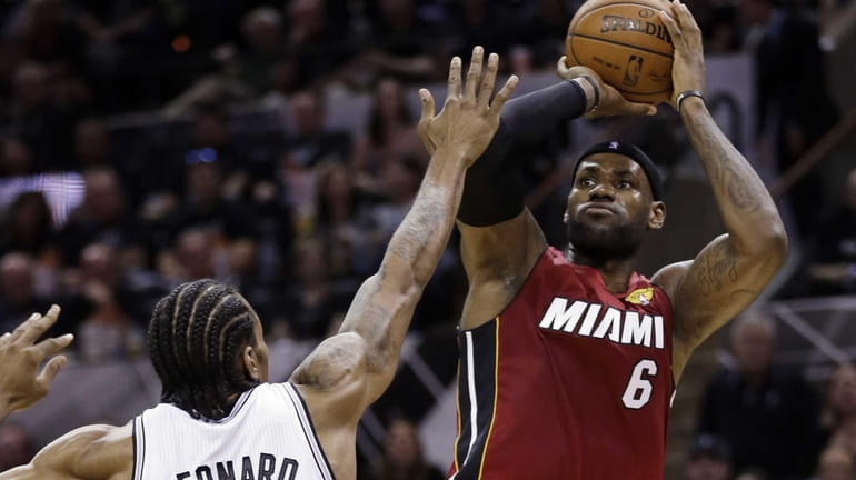 Miami Heat forward LeBron James shoots over San Antonio Spurs...