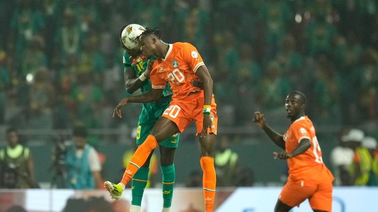 Senegal's Moussa Niakhate, left, challenges for the ball with Ivory...