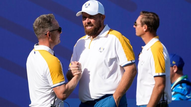 Europe's Team Captain Luke Donald , left shakes hands with...