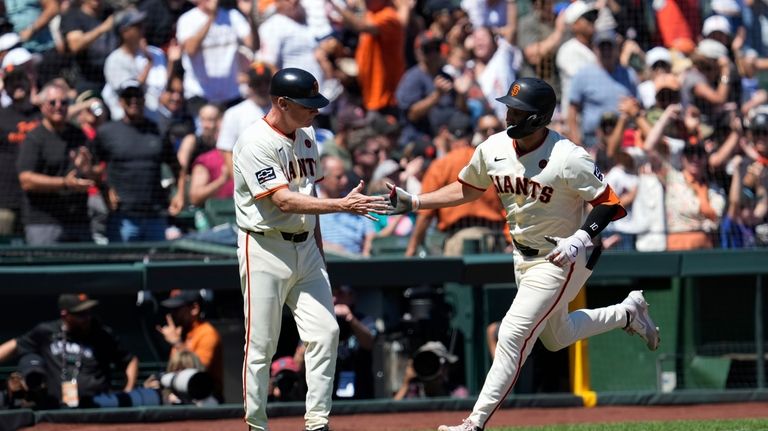 San Francisco Giants' Casey Schmitt, right, celebrates with third base...