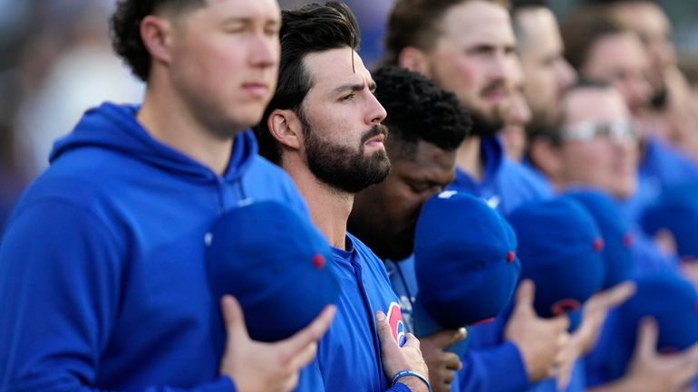 Chicago Cubs shortstop Dansby Swanson, second from left, stands with...