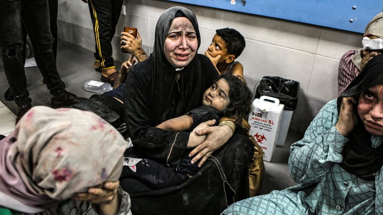 Wounded Palestinians lay at the al-Shifa hospital, following Israeli airstrikes,...
