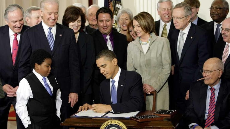 President Barack Obama signs the Affordable Care Act in the...