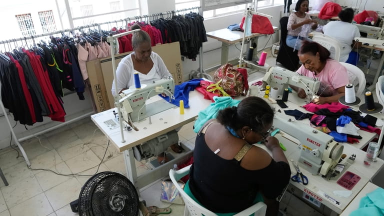 Lupe, top left, sews at a cooperative created to support...