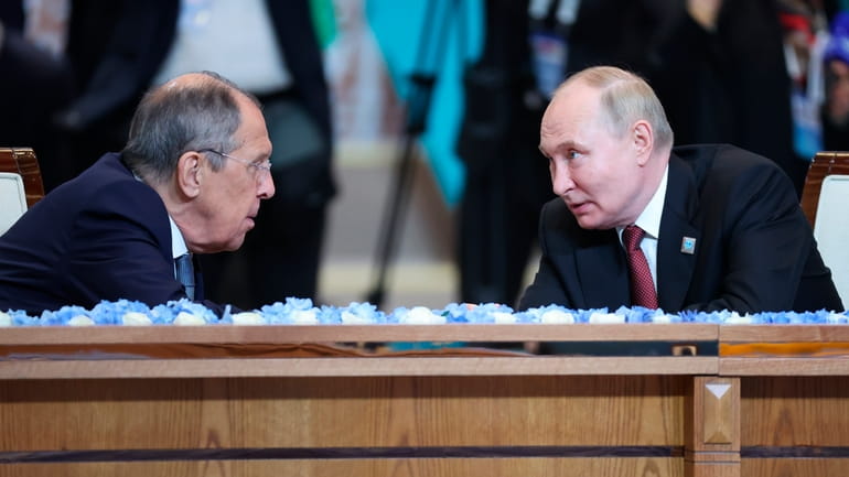 Russian President Vladimir Putin, right, and Russian Foreign Minister Sergey...