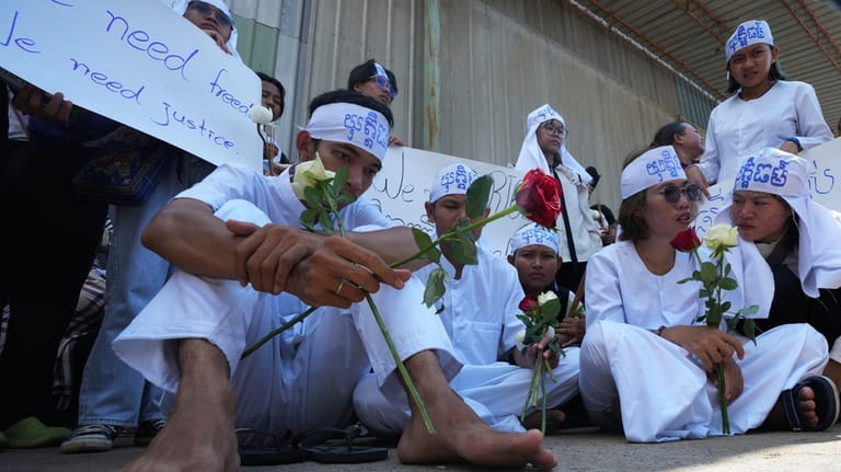 Environmental activists, front row, sit during a protest near Phnom...