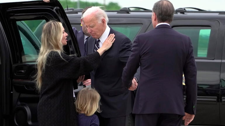 President Joe Biden talks with his son Hunter Biden, right,...