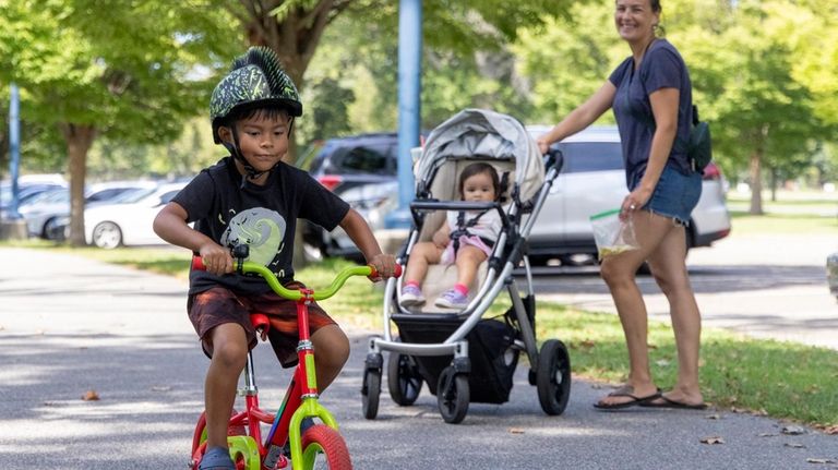 Greyson Concepcion, 6, of Levittown, rides his bike with mom...