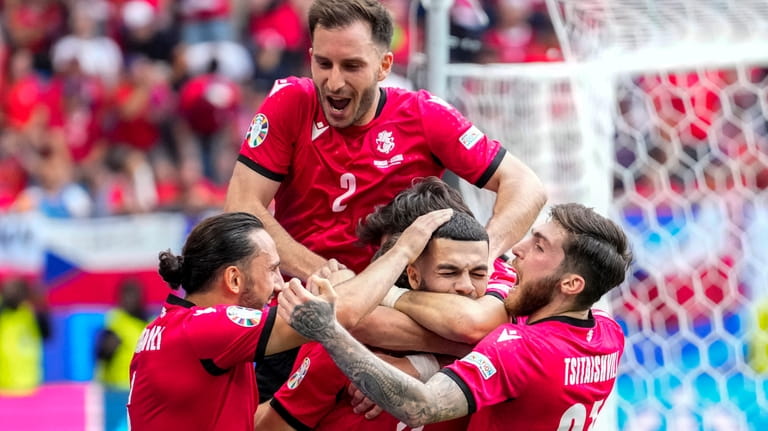 Georgia's players celebrate their side's opening goal during a Group...