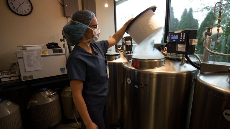 Embryologist Kerriann Papszycki works in the cryogenic storage room at RMA...