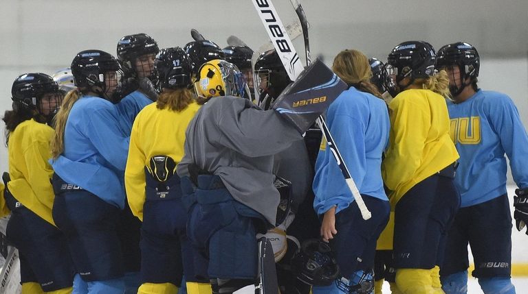 LIU women's ice hockey players gather at the end of...