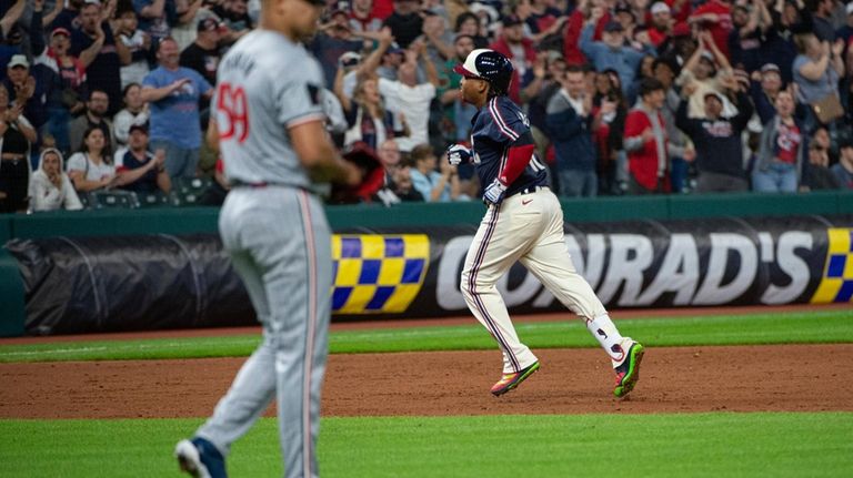 Cleveland Guardians' Jose Ramirez, back right, rounds the bases after...