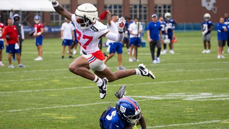 New York Giants safety Jason Pinnock (27) jumps over New...