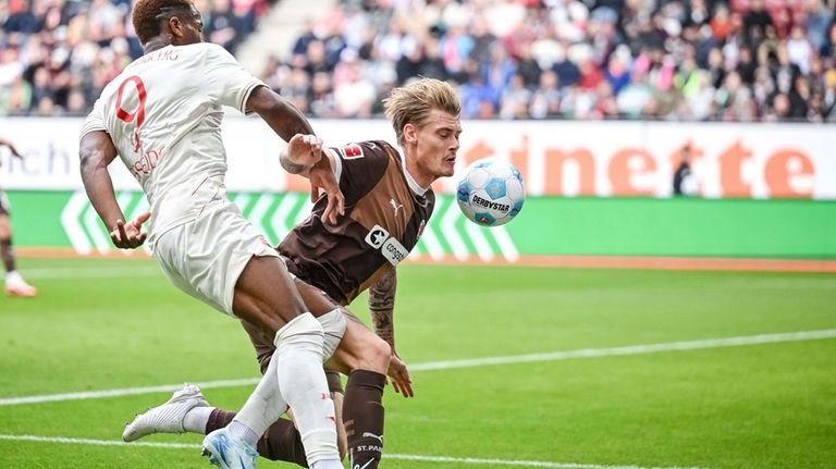 Augsburg's Samuel Essende, left, and St. Pauli's Eric Smith vie...