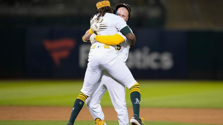 Oakland Athletics' Seth Brown, right, is hugged by Lawrence Butler...