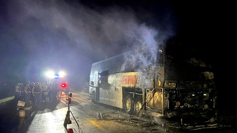 In this photo provided by J.D. Scholten, a bus carrying...