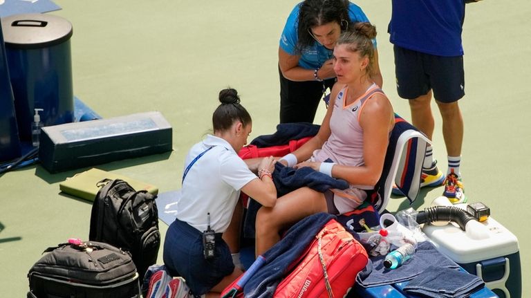 Beatriz Haddad Maia, of Brazil, is checked by medical personnel...