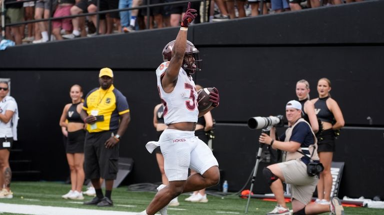 Virginia Tech running back Bhayshul Tuten (33) runs into the...