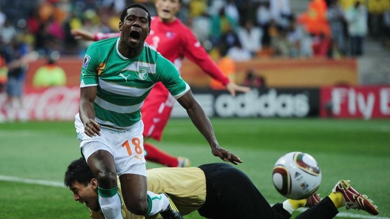 Abdul Kader Keita of the Ivory Coast is tackled by...