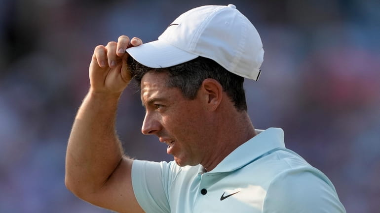 Rory McIlroy, of Northern Ireland, reacts after missing a putt...