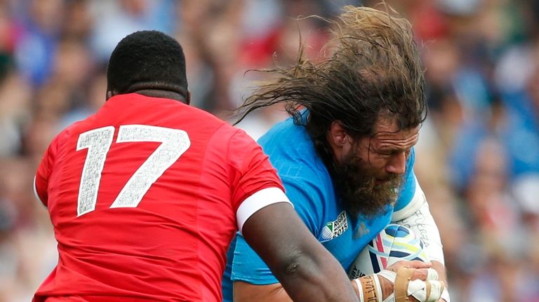 Italy's Martin Castrogiovanni is tackled by Canada's Djustice Sears-Duru during...