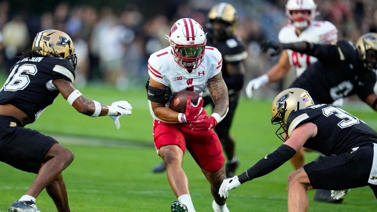 Wisconsin running back Chez Mellusi (1) runs between Purdue defensive...