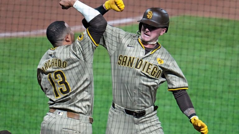 San Diego Padres' Jackson Merrill, right, celebrates with Manny Machado...