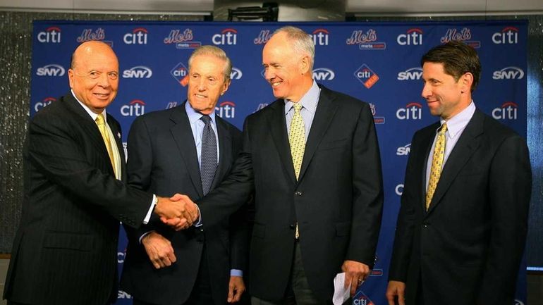 Mets GM Sandy Alderson, second from right, stands with team...