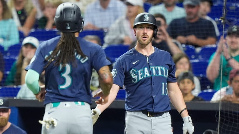Seattle Mariners' J.P. Crawford (3) is congratulated by Mitch Garver...
