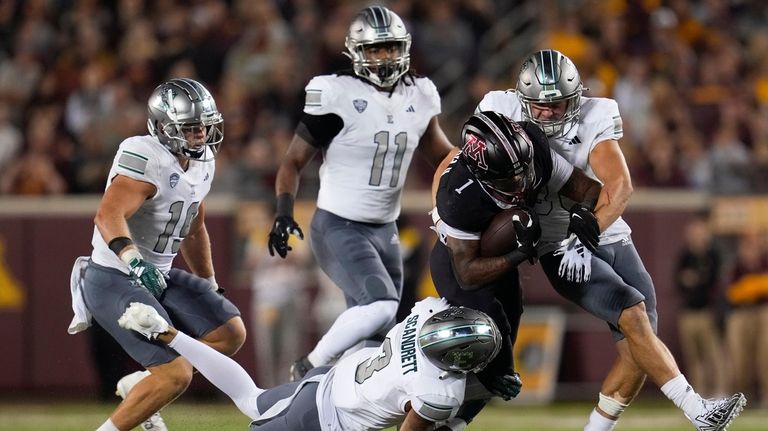 Minnesota running back Darius Taylor is tackled by Eastern Michigan...