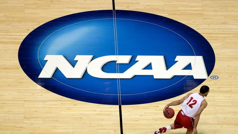 Wisconsin's Traevon Jackson dribbles past the NCAA logo during practice...