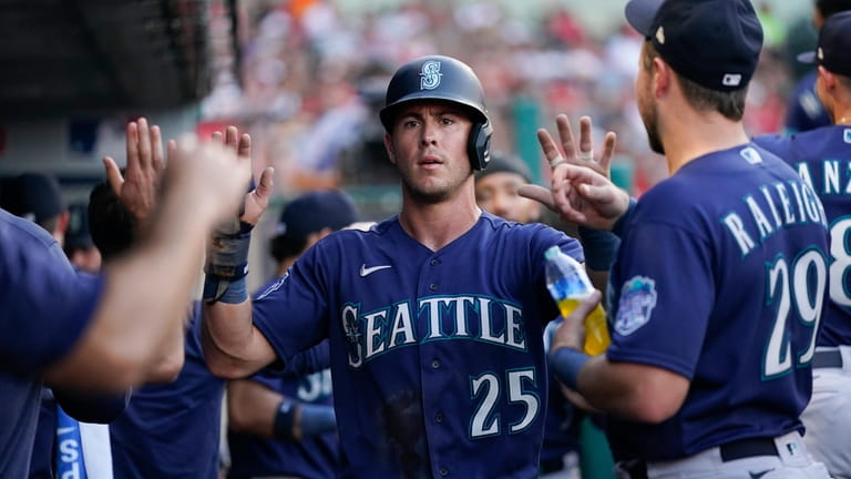 Los Angeles Angels' C.J. Cron (25) celebrates in the dugout after scoring  on a double by Mike Moustakas against the Seattle Mariners during the sixth  inning of a baseball game Thursday, Aug.