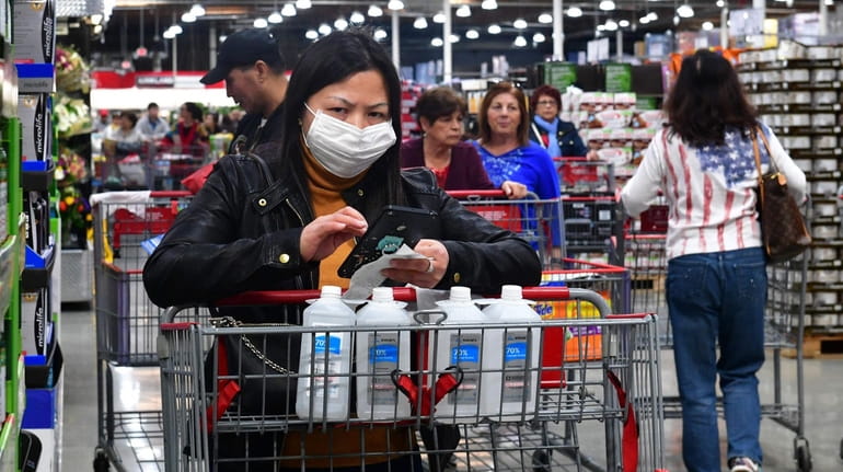 A shopper concerned about the global coronavirus outbreak wears a...