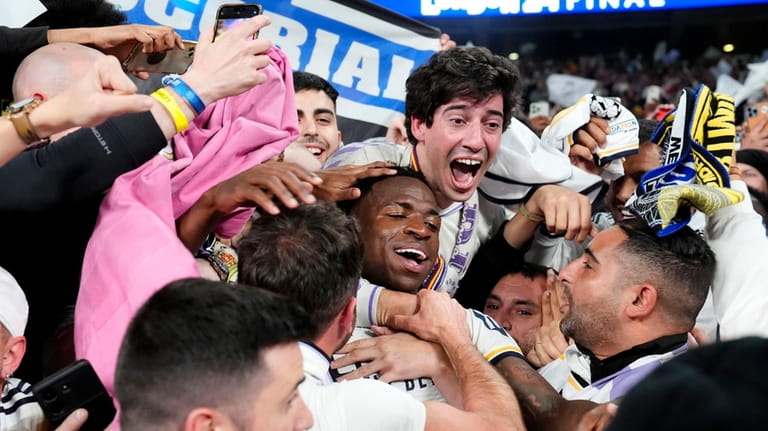 Real Madrid's Vinicius Junior celebrates with the fans after winning...