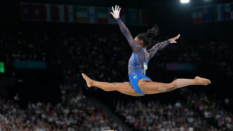 Simone Biles, of the United States, performs on the balance...