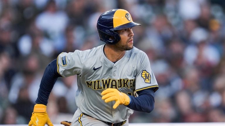 Milwaukee Brewers' Blake Perkins runs out a one-run triple against...