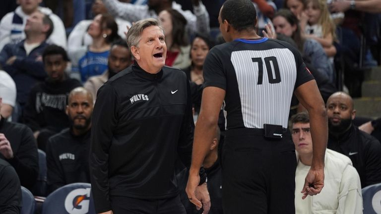 Minnesota Timberwolves head coach Chris Finch, left, reacts toward referee...