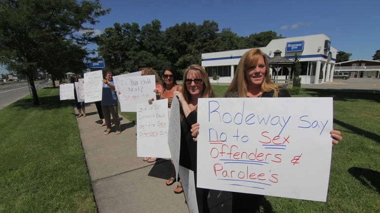 Protesters carry signs if front of Rodeway Inn in Ronkonkoma....