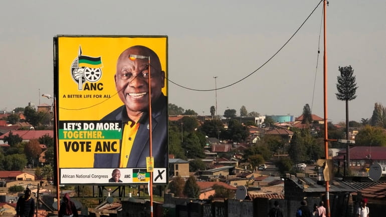 An election poster, with President Cyril Ramaphosa atop a pole...