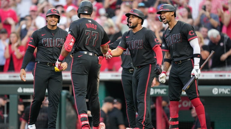 Cincinnati Reds' Rece Hinds (77) celebrates with teammates, from left...