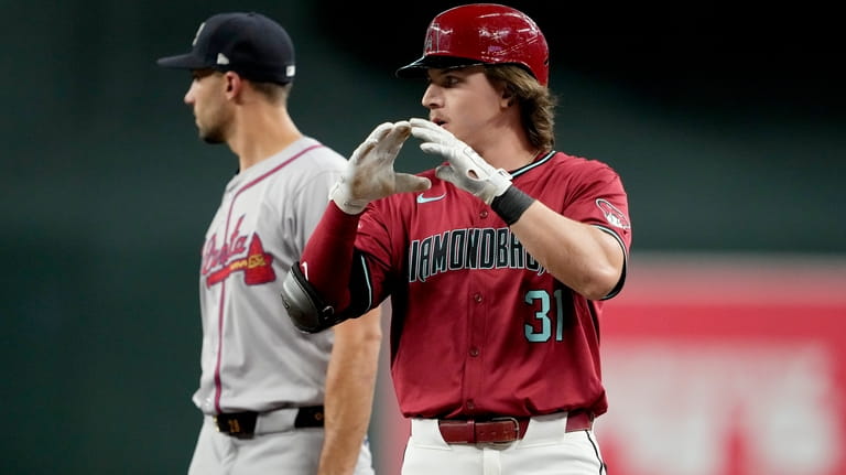 Arizona Diamondbacks' Jake McCarthy motions towards his dugout after a...