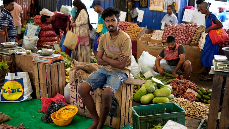 A vendor waits for customers at a market place in...