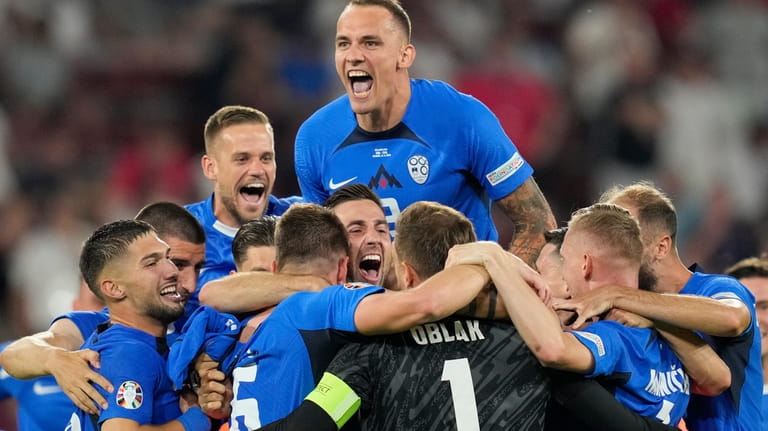 Slovenia's players celebrate at the end of a Group C...