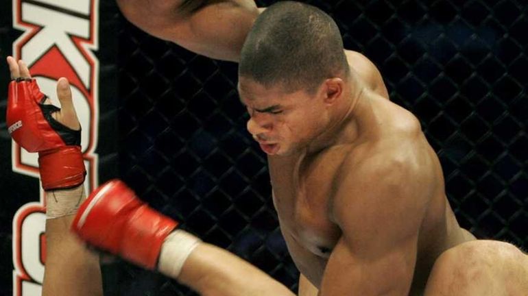 Alistair Overeem, top, punches Paul Buentello en route to winning...