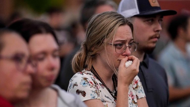 Mourners pray during a candlelight vigil for the slain students...