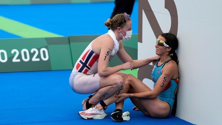 Claire Michel, of Belgium, is assisted by Lotte Miller of...