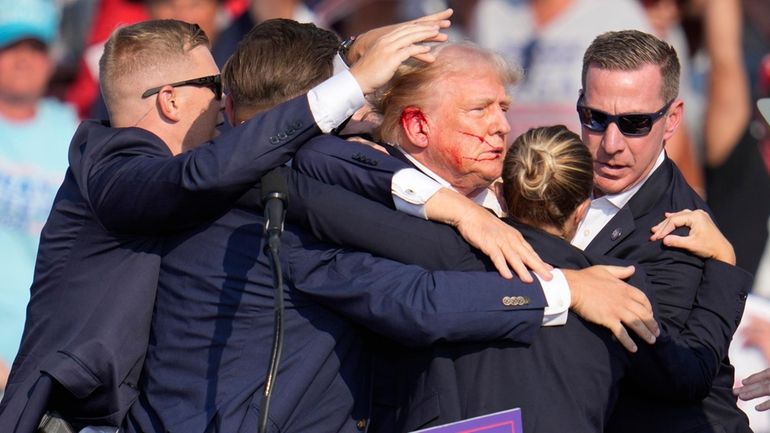 Former President Donald Trump is helped off the stage by Secret...