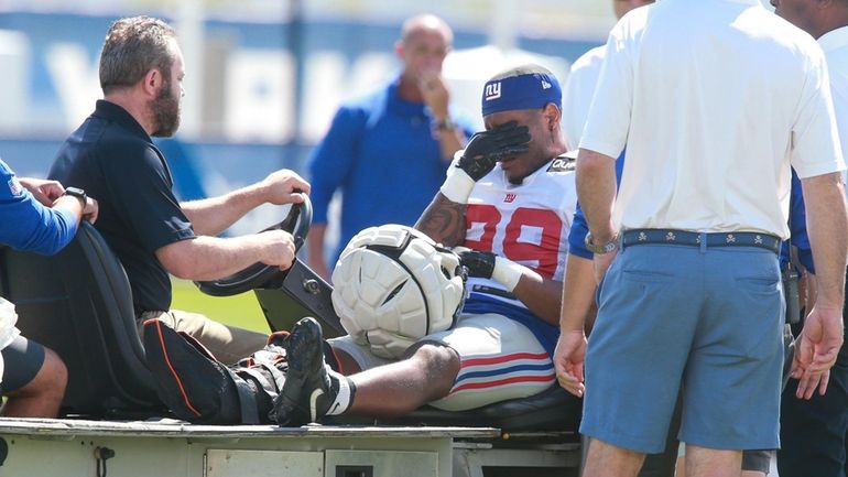 Giants running back Tyrone Tracy Jr. is carted off the...