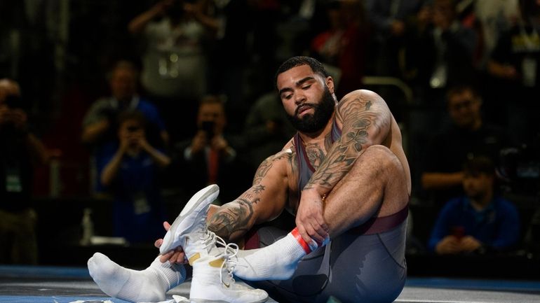 Minnesota's Gable Steveson leaves his shoes on the mat, a...