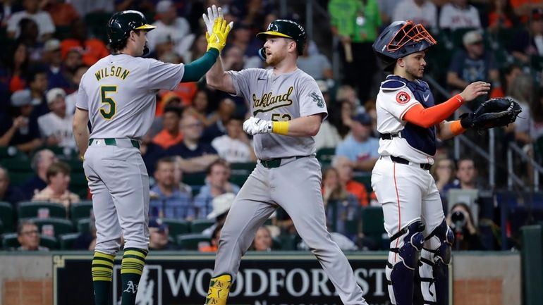 Oakland Athletics' Jacob Wilson (5) and Kyle McCann, center, celebrate...